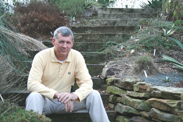 Tony Avent sitting on steps in yellow shirt
